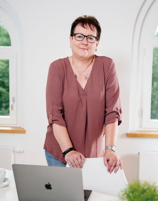 Mandy Staffa steht hinter einem Schreibtisch.